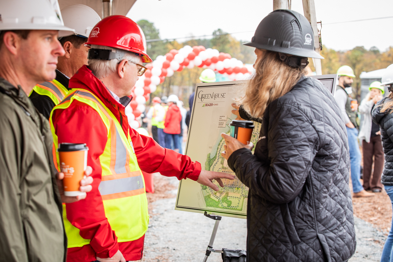 people stand at a board displaying the community map